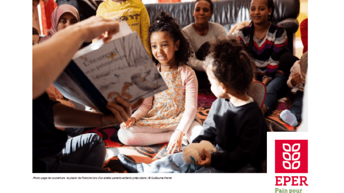 Enfants lisant un livre tenu par un adulte